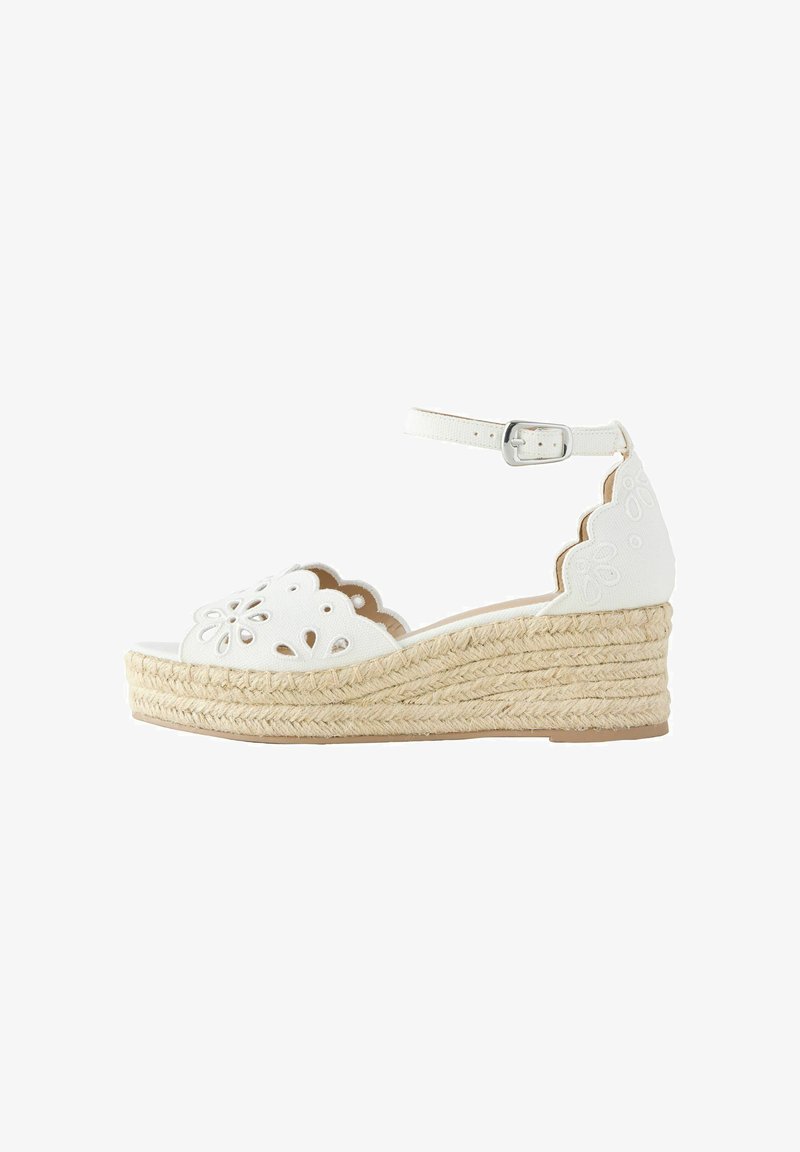 Sandale compensée espadrille blanche avec découpes florales festonnées et boucle sur bride de cheville sur semelle en jute tressée.
