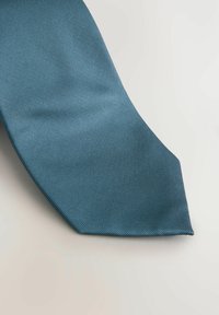 Teal vævet slips med et struktureret mønster, der har en spids ende og glat stof. Farven er livlig og konsekvent hele vejen igennem.