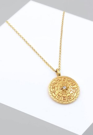 Goldene Halskette mit einem runden Anhänger, der mit eingravierten Tierkreiszeichen und einem zentralen Edelstein versehen ist, an einer zarten Kette aufgehängt.