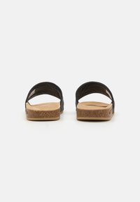 Sorte sandaler med kork såle, åpen tå og bøyde bakre reim. Glatt overmateriale og teksturert innersåle for komfort.