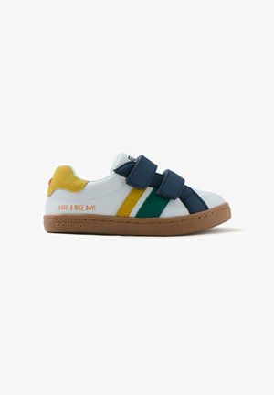 Sneaker blanc avec des rayures bleues, vertes et jaunes, sangles Velcro, semelle marron, et le texte "BONNE JOURNÉE !" sur le côté. Marque Gioseppo.