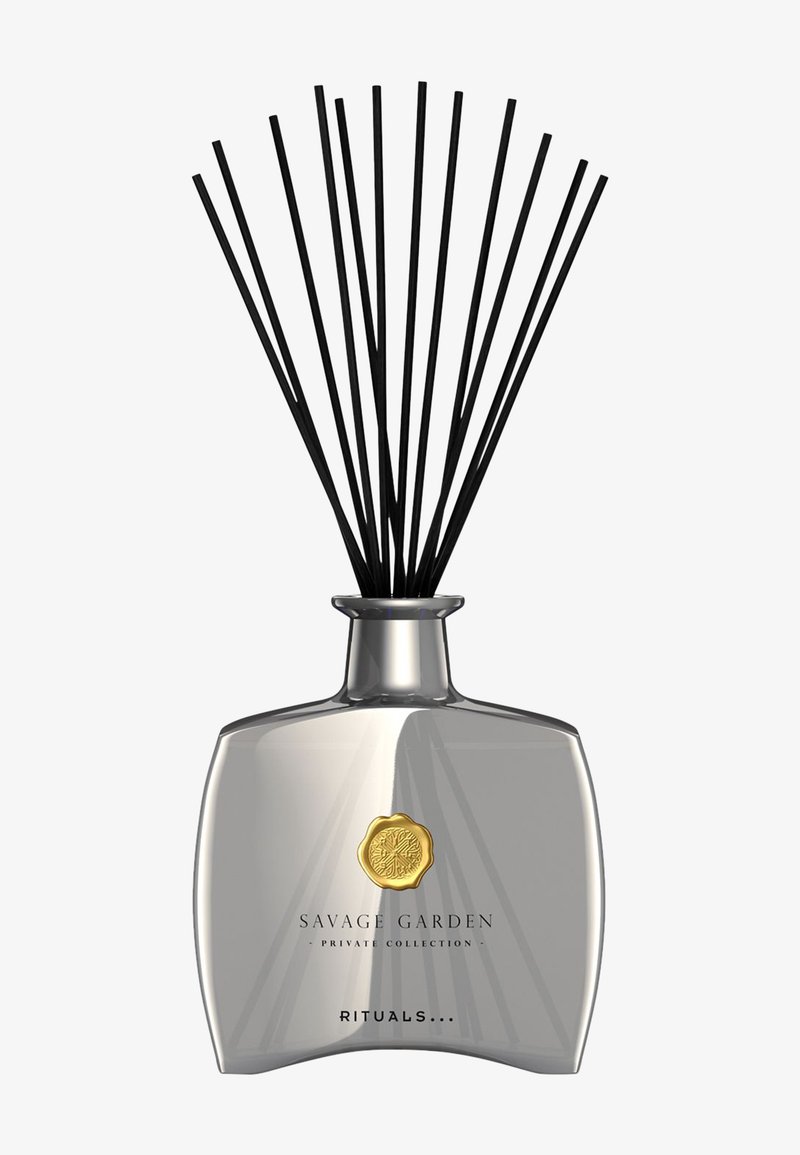 Glassdiffuser med sølvfinish, med en gull-emblem, omgitt av svarte rørpinner. Elegant, minimalistisk design med geometriske mønstre.