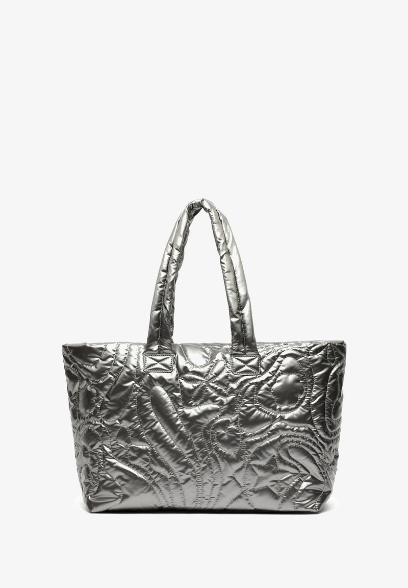 Sac cabas matelassé argenté brillant avec deux anses rembourrées et motifs abstraits cousus sur fond blanc.