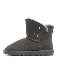 Stivale alla caviglia in suede grigio con punta rotonda, foderato in pelliccia sintetica e decorato con borchie argento sul lato esterno. Suola piatta in gomma con trazione.