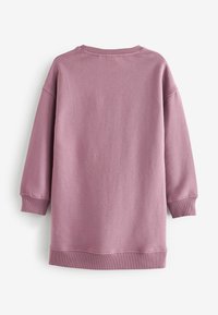 Vaaleanpunainen collegepaita, jossa on pitkät hihat, ribbireunus kaulassa ja teksturoitu pinta. Suunnittelu on yksinkertainen ilman näkyviä logoja tai kuvioita.