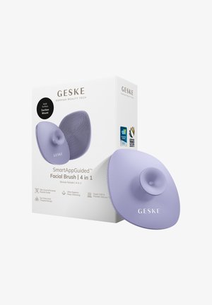Lavendel GESKE 4-in-1 SmartApp-geleide gezichtsborstel met zuignapmontuur en getextureerd siliconen oppervlak, afgebeeld naast de witte verpakking.