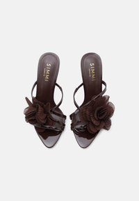 Brune sandaler i lakkskinn med en plissert blomsterdekorasjon ved tåen, åpen hæl og slanke stropper. Teksturert innersåle med merkevare.