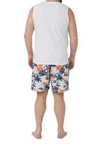 Weißes ärmelloses Tanktop und mehrfarbige Badeshorts mit einem tropischen Palmendruck in Blau-, Orange- und Cremetönen, aus leichtem Stoff.