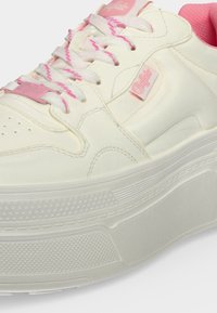 Λευκά και ροζ sneakers με χοντρή σόλα, κορδόνια με ροζ λεπτομέρειες, επενδυμένο κολάρο και μικρή ροζ ετικέτα με το λογότυπο στη πλευρά.