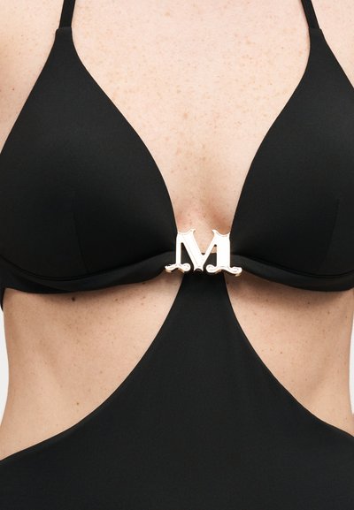 Μαύρο ολόσωμο μαγιό με βαθιά κοψίματα και ασημένιο διακοσμητικό κούμπωμα "M" στο κέντρο μπροστά, ανάμεσα στα cups.