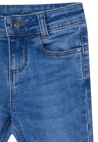 I jeans in denim blu presentano un taglio classico con chiusura a bottone, design a cinque tasche e cuciture a contrasto per resistenza e stile.
