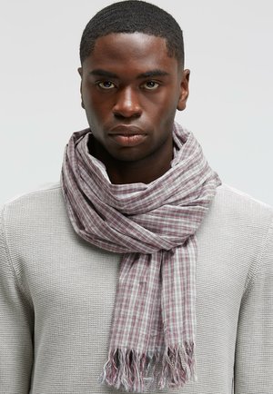 Lightweight checked scarf in shades of red, gray, and white, featuring a frayed edge and soft texture, worn around the neck.