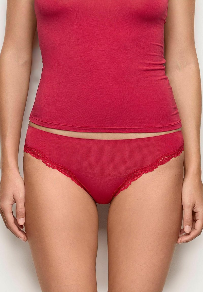 Top in cotone rosso misto abbinato a mutandine rosse con pizzo, caratterizzato da una morbida texture e un design aderente.
