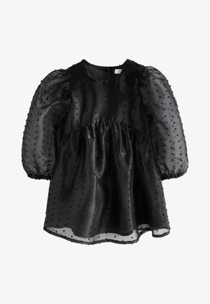 Robe courte noire avec manches bouffantes transparentes et tissu texturé à pois, corsage ajusté et jupe froncée.