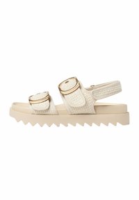 Beige sandals with textured fabric straps, gold accents, and a zigzag rubber sole. Features two adjustable buckles for fit.