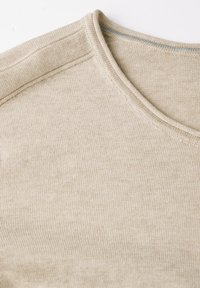 Beige neulekangas, jossa on sileä pinta, pyöreä pääntie ja hillityt ompeluseikat. Pehmeä, kevyt materiaali.