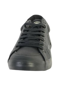 Zapatillas negras con parte superior de cuero liso y textil, punta redonda y cordones planos, con suela de goma texturizada y un branding sutil.