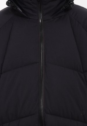 Zwarte pufferjack met een ritssluiting aan de voorkant, voorzien van een doorgestikte afwerking en een capuchon met trekkoord. Glad textuur met tonale branding op de zoom.