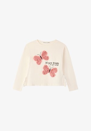 Camicia bianca a maniche lunghe con due applicazioni di farfalle rosa testurizzate e testo nero che recita: "lascia che i tuoi sogni siano le tue ali."