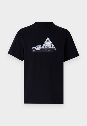 Melna kokvilnas T-krekls ar attēlu, kurā redzams balts kravas auto ar trīsstūra kravu. Auto ir dekorēts ar abstraktiem dizainiem un uzrakstiem.
