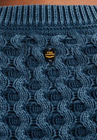 Dunkelblauer, gestrickter Pullover mit einem strukturierten Wellenmuster. Verfügt über einen gerippten Kragen und ein in das Strickwerk eingewebtes PME Legend-Logoetikett.