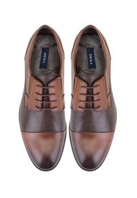 Braune Lederdressschuhe mit einem strukturierten Obermaterial, einer glatten Zehenkappe und einem dekorativen Schnürdesign. Insignie "DESA" im Inneren sichtbar.
