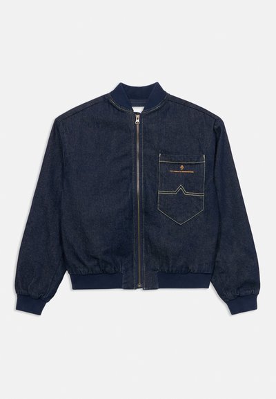 Σκούρο μπλε denim bomber μπουφάν με φερμουάρ μπροστά, ελαστικά μανσέτες και γείσο, και μια μεγάλη ραμμένη τσέπη στο στήθος με κίτρινο κείμενο και σχέδιο.