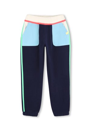 Pantalon bleu marine avec poches avant bleu clair, ceinture beige avec bordure rouge et bandes latérales vertes, poignets élastiques aux chevilles.