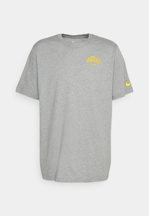 Graues T-Shirt mit kurzen Ärmeln, gelbem Los Angeles Lakers Logo auf der Brust und gelbem Nike-Swoosh am linken Ärmel.