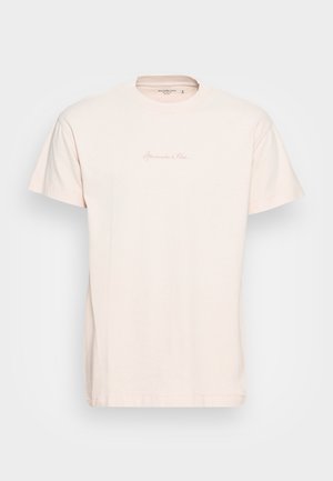 T-shirt in cotone rosa chiaro con scollo rotondo, maniche corte e un logo sottile stampato sul davanti. Tessuto morbido, vestibilità casual.