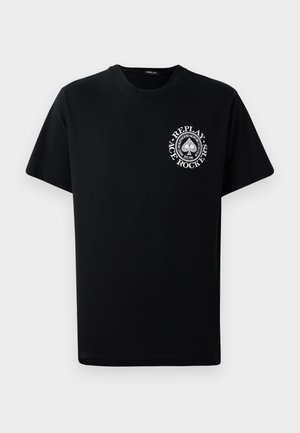 Camiseta de algodón negra de manga corta, con un logo circular blanco en el lado izquierdo del pecho que incluye texto y diseños gráficos.