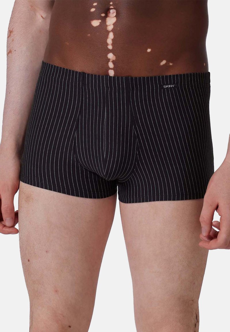 Boxer in bianco e nero a righe con una vestibilità aderente, dotati di un logo sulla cintura, tessuto morbido e apertura con pattina sul davanti.