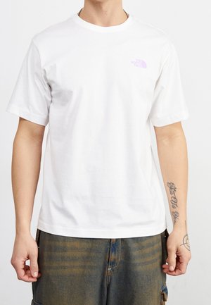 Weißes Baumwoll-T-Shirt mit Rundhalsausschnitt und kurzen Ärmeln. Mit einem kleinen lila Logo auf der linken Brust. Glatte Textur.