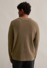 Pull en mailles vert olive avec une texture côtelée et un col rond, doté de manches longues et d'un ourlet droit, vu de dos.