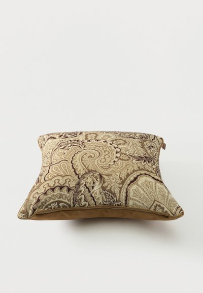 Coussin décoratif carré avec un motif paisley beige et marron complexe et un bord inférieur en similicuir marron.