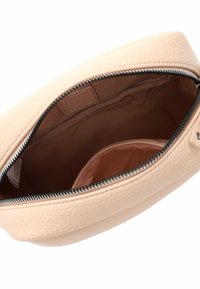 Borsetta in pelle color pesco con superficie testurizzata, chiusura con zip e fodera interna di un morbido colore neutro.