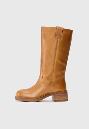 Tan leather knee-high boot with a rounded toe, stitched accents, block heel, and a pull tab at the top for easy wear.