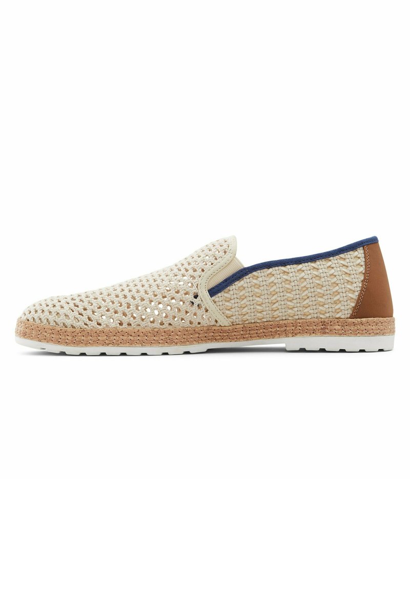 Buty wsuwane z kremową plecionką i perforowanym wzorem, naturalnym korkowym śródstopiem, brązowym skórzanym akcentem na pięcie oraz białą gumową podeszwą.