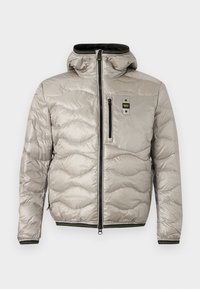 Ανοιχτό γκρι μπουφάν καπιτονέ με κουκούλα, μπροστινό φερμουάρ, τσέπη στο στήθος με φερμουάρ και λογότυπο, και μανσέτες και τελείωμα με μαύρο περίγραμμα.