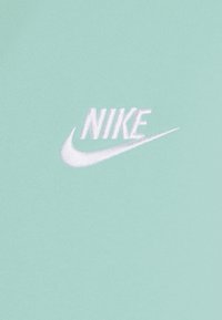 T-shirt in tessuto verde menta con logo Nike ricamato in bianco. Texture liscia con scollatura rotonda e maniche corte.