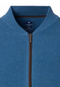 Niebieski sweter z dzianiny z wysokim kołnierzem, zapięciem na zamek błyskawiczny i teksturowanym materiałem. Posiada brązowy zamek i akcenty w postaci stębnowania. Widoczna metka marki.