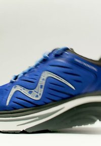 Blauer Sportschuh mit schwarzer Sohle und weißem Zwischensohlendetail sowie einem reflektierenden silbernen Logo an der Seite.