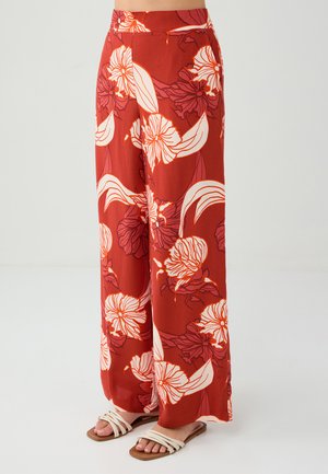 Pantaloni larghi rossi con un audace motivo floreale in bianco e rosa. Realizzati in tessuto leggero con una consistenza morbida e una cintura elastica.
