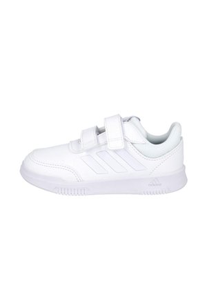 Zapatilla blanca Adidas con dos tiras de velcro, tres franjas laterales, cuello acolchado y suela texturizada, mostrada de perfil.