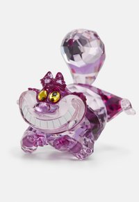 Kristallfigur av en flinande katt i varierande lila nyanser, med gula ögon och intrikata facetter, som liknar en tecknad karaktär.