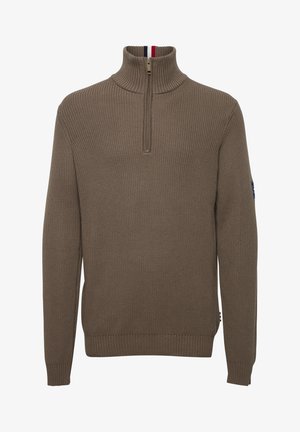 Bruine ribbelgebreide trui met halve rits, hoge kraag en contrasterende rode, witte en blauwe accenten bij de hals.