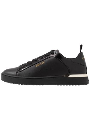Czarny niski sneaker z przodu na sznurówki, gładkie i fakturowane materiały, złote logo "CRUYFF" oraz gruba gumowa podeszwa z metalicznym akcentem.