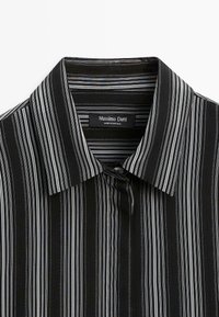 Chemise noire à rayures verticales blanches et grises, col classique, avec étiquette Massimo Dutti à l'intérieur du col.