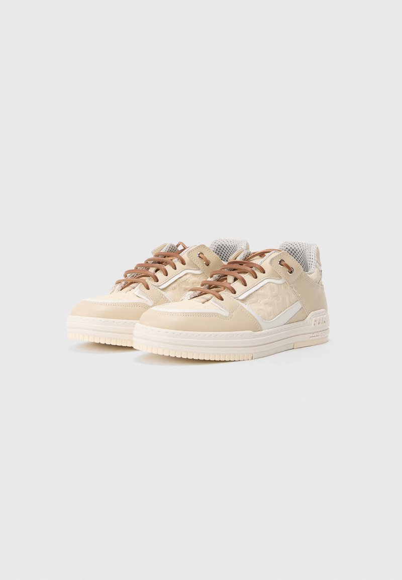 Beige sneakers made of leather with mesh accents, feature brown laces, textured paneling, and a chunky rubber sole.