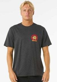 Dark gray cotton t-shirt featuring short sleeves and a round neck. Front left chest has a red and yellow circular logo with a lion graphic.
